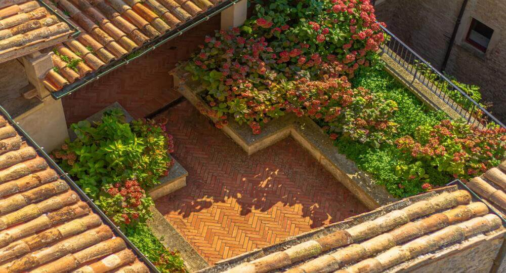 balcone fiorito ricavato su una terrazza ad asola all'ultimo piano di un palazzo del centro storico