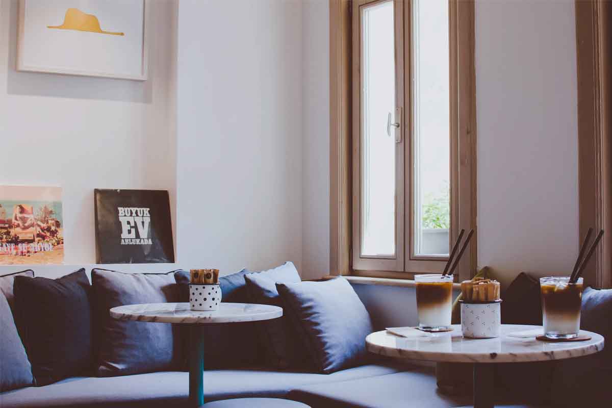 un soggiorno moderno con divano blu e infissi salvaspazio per le finestre effetto legno